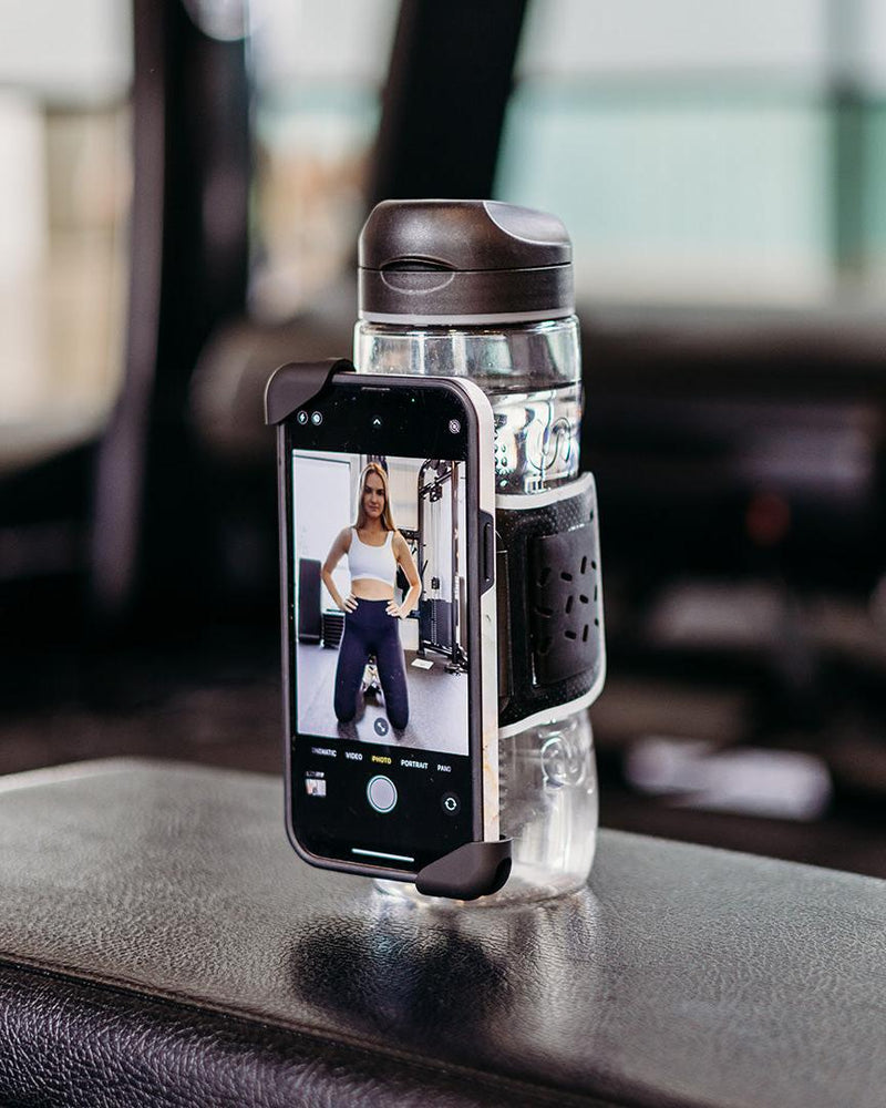 Black Re-Active Sport Phone Holder attached to a clear water bottle, displaying a woman in workout gear.