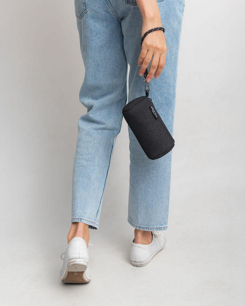 Black denim neoprene wristlet clutch with detachable strap, held by a person in jeans.